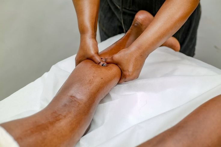 Therapist applying firm knuckle pressure during a deep tissue massage on the calf at Blossoms Massage Spa, Kilimani